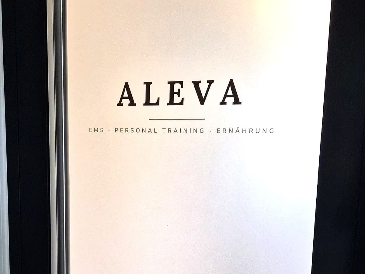 Die Eingangstür von Aleva mit dem Schriftzug und den Öffnungszeiten